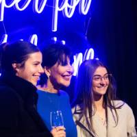 President Mantella poses with two grads in front of Laker sign